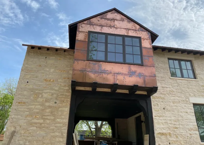 Copper metal panel facade on a stone building for Roof Repair in Celina