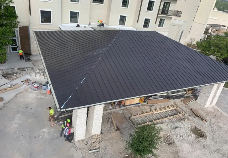 Metal roofing installation team working on a commercial building in Celina